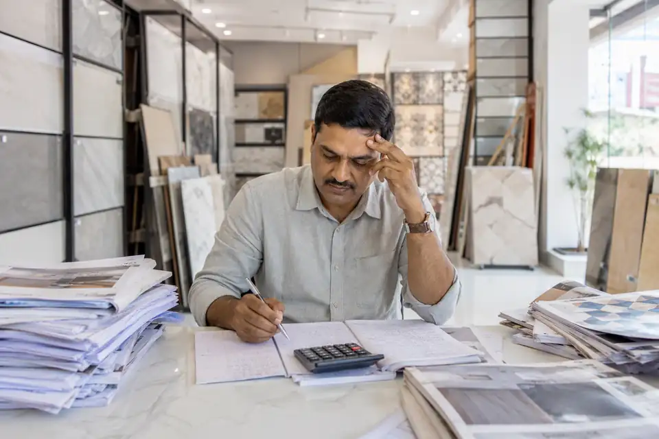 A Tiles channel partner working out incentives by hand with paper circulars and registers