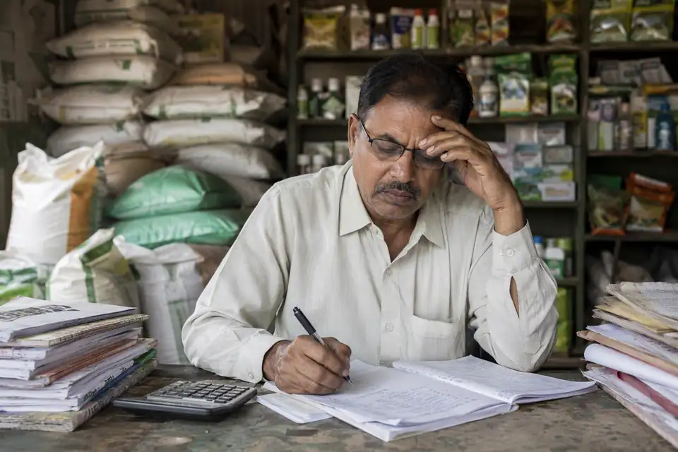 A Chemicals & Fertilizers channel partner working out incentives by hand with paper circulars and registers