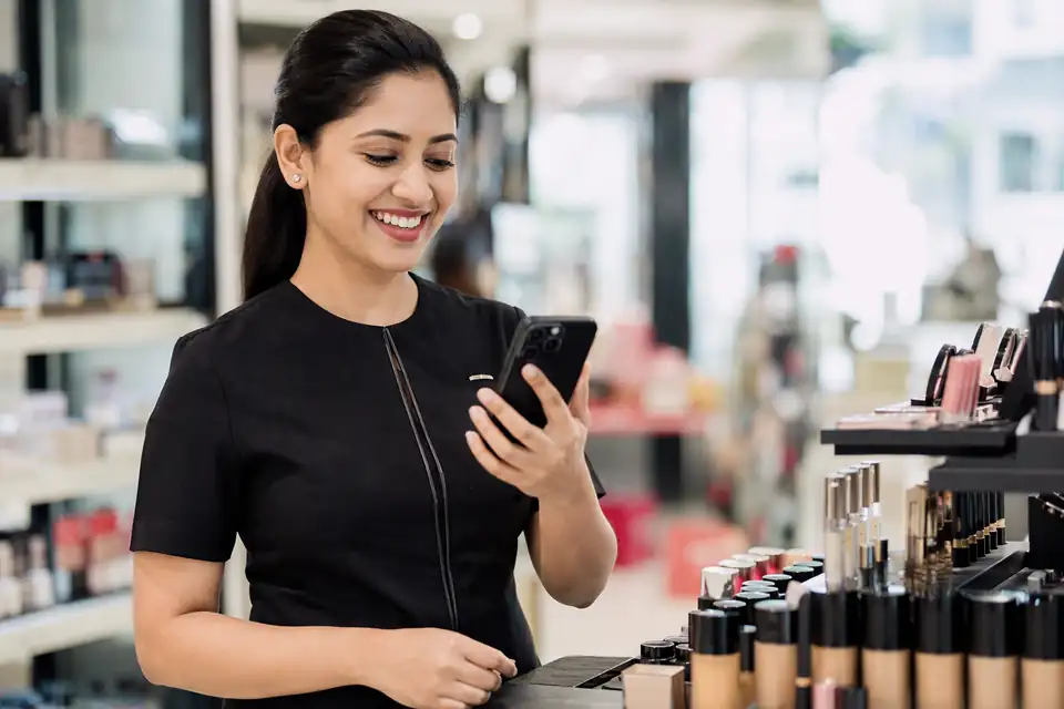 A happy Cosmetics channel partner seeing incentive progress on his phone with Unotag